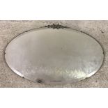 A vintage wall hanging hall mirror with bevel edged glass and chrome floral decoration to top.