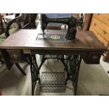 A vintage Singer cast iron based treadle sewing machine with drop leaf end.