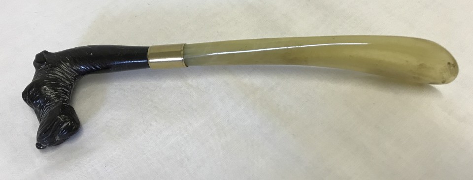 An early 20th century Italian shoe horn with dog's head handle and horn 'blade'.