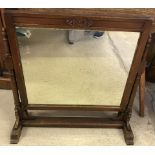 A vintage dark wood framed swing mirror with turned detail to frame.