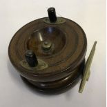 A vintage walnut star-back fishing reel with brass fittings and check control.