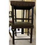 A pair of dark wood leather topped stools.