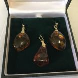 A pair of large drop amber earring together with an amber drop pendant.