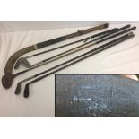 A Collection of vintage golf clubs and an early hockey stick.