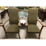 A pair of vintage dark wood framed carver dining chairs with sprung seats and green upholstery.