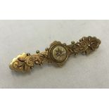Antique bar brooch in 15ct gold set with a central white sapphire.