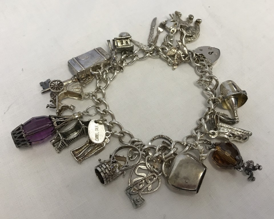 Silver charm bracelet with 20 charms.