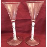 A pair of Georgian wine glasses with airtwist stems, trumpet shaped bowls and conical feet.