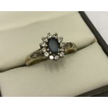 A hallmarked 9ct gold ring set with a central blue stone and cubic zirconias.