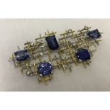 Striking diamond and sapphire woven design brooch.