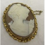 Carved cameo brooch in hallmarked 9ct gold ornate mount with safety chain.