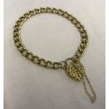 9ct gold bracelet with pierced heart shaped clasp and safety chain.