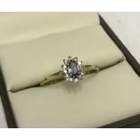 Pretty hallmarked 9ct gold ring set with oval sapphire surrounded by small diamonds.