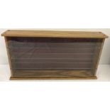 A wooden framed wall hanging display case.