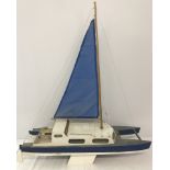 A scratch built sailing yacht in blue and white.