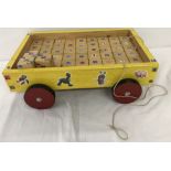 A wooden pull along child's trolley filled with wooden blocks decorated with Disney stickers.