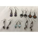 6 pairs of silver earrings set with amber and stones.