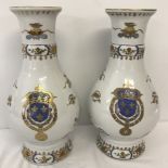 A pair of bulbous vases with French armorial crests and gilt decoration.