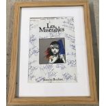 A framed and glazed souvenir brochure from Les Misérables sign by cast members.