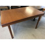 A vintage teak drawer leaf dining table with central leaf.