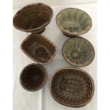 6 vintage brown stoneware jelly moulds of various sizes and designs.