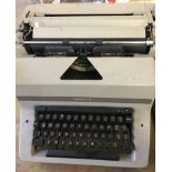 A vintage Imperial typewriter with dust cover.