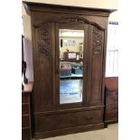 A dark oak Art Nouveau single door wardrobe with carved detail to front and mirrored door.