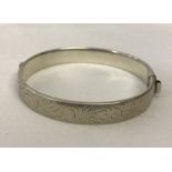 Hallmarked silver hinged bangle with decorative engraving.