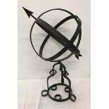 A free standing wrought iron globe garden ornament.