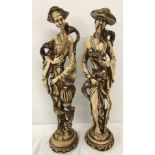 A pair of large resin oriental figures, a gentleman and lady in traditional dress holding birds.