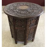 A vintage carved occasional table with octagonal shaped base and inlaid detail to top.
