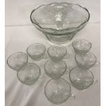 A large clear glass punch bowl decorated with grape and vine design.