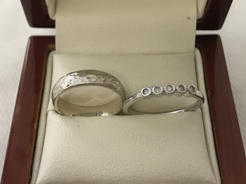 2 silver rings, one set with 5 small diamonds.