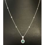 An 18ct white gold diamond and emerald necklace.