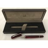 A modern Dunhill ball point pen with burgundy marbled finish. In original box.