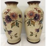A large pair of opaque glass vases with hand painted flower decoration in neutral colours.