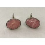 A pair of silver cufflinks set with pink agate cabochons.