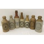 A collection of 7 various stoneware ginger beer bottles.