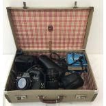 A vintage pioneer luggage small suitcase containing cameras and lenses.