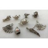 9 silver and white metal bracelet charms. Some with moving parts.