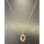 A hallmarked 9ct gold pendant set with oval Smoked Quartz on a very fine 9ct gold chain.