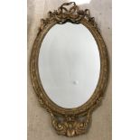 A large English late Victorian oval ornate gesso mirror.