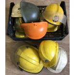 A box of hats and helmets to include fireman's, tin helmets and engineering.