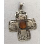 A 925 silver cross pendant set with central amber cabochon.