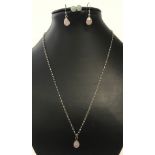 A silver pendant and chain set with rose quartz and matching earrings.