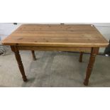 A vintage pine kitchen table with turned legs.
