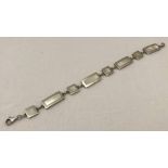 A silver bracelet, links set with square and rectangular shaped shell inserts.