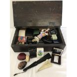 A vintage wooden box with lift up lid full of mixed items.