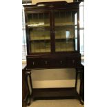 A mahogany 2 door display cabinet with leaded glass doors and 2 interior fabric lined shelves.