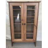 A modern 2 door pine display cabinet with interior shelves.